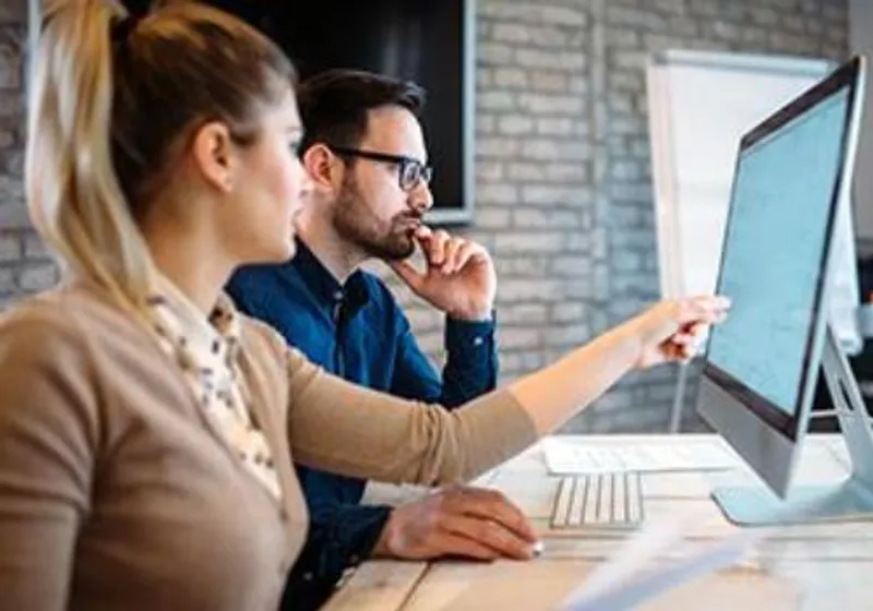 Photo of two people looking at screen